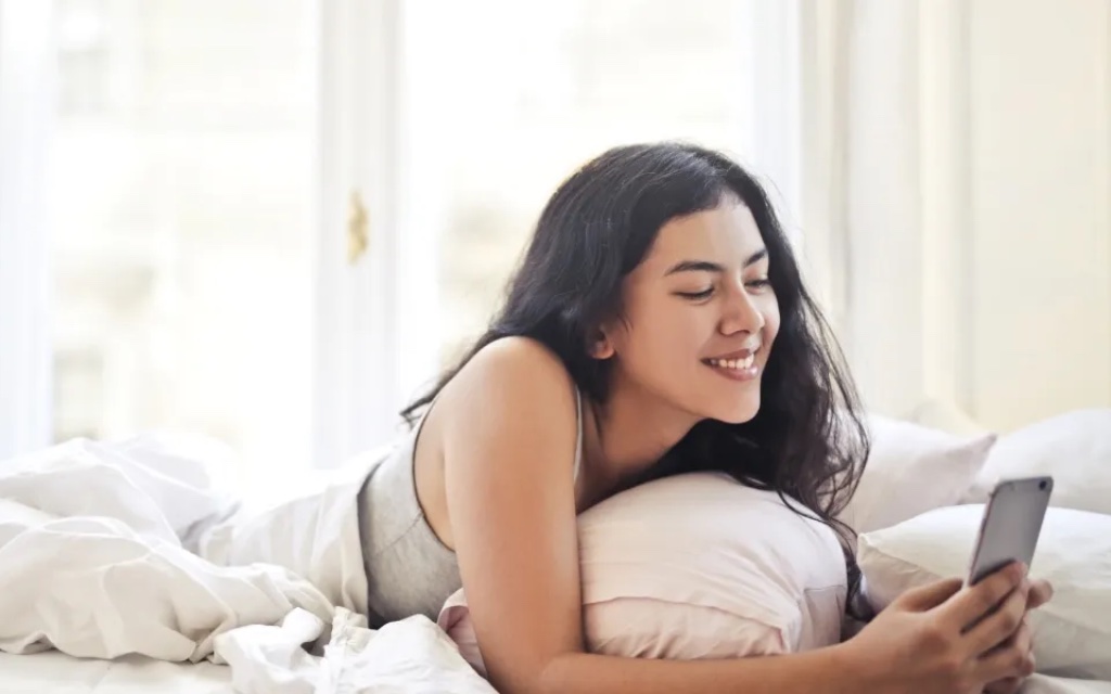 Girl Texting on Bed